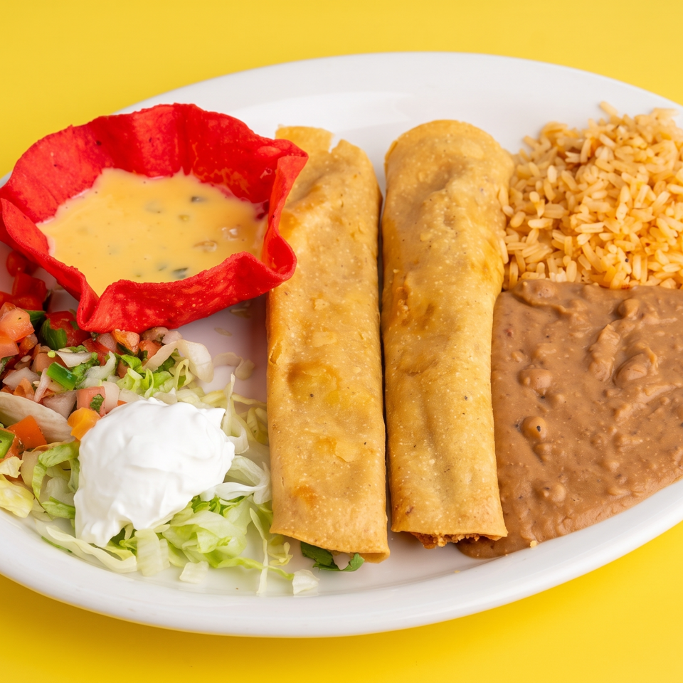 Mexican platter with two crispy flautas, rice, refried beans, pico de gallo, lettuce, sour cream, and queso in a red tortilla bowl.