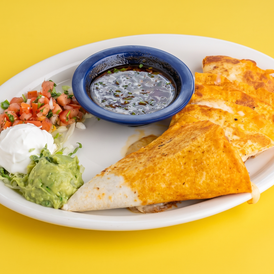 Cheesy quesadilla wedges served with pico de gallo, guacamole, sour cream, and dipping sauce on a white plate.