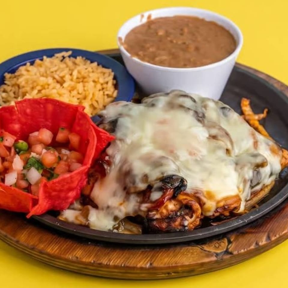 Cheesy grilled entrée with mushrooms, Mexican rice, beans, and fresh pico de gallo in a red tortilla bowl.